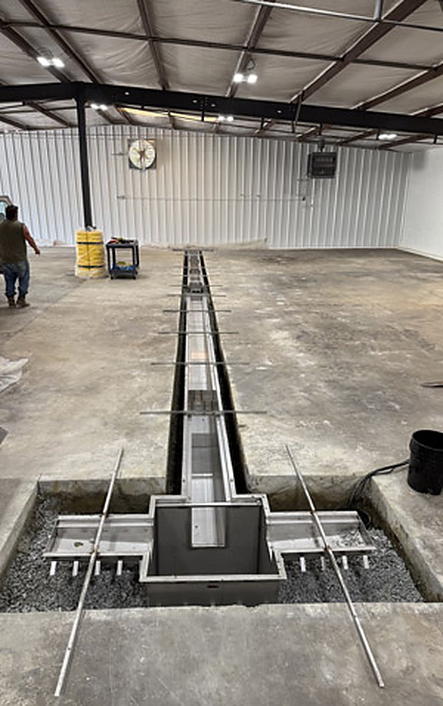 Machine foundation and trench drain formed inside an industrial building