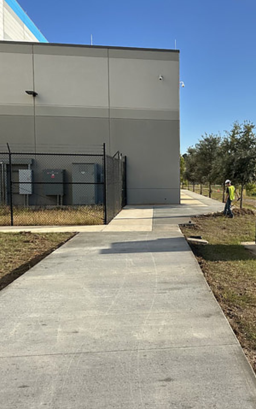 New sidewalk and transformer pad alongside a commercial building