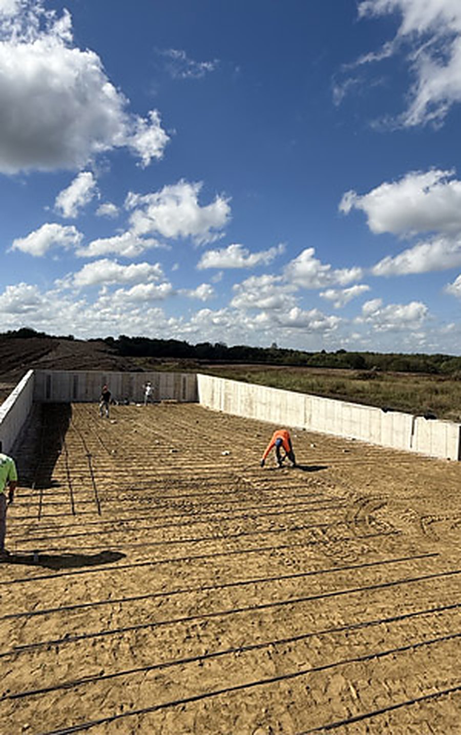 Reinforcing steel tied over a prepared subgrade between poured foundation walls