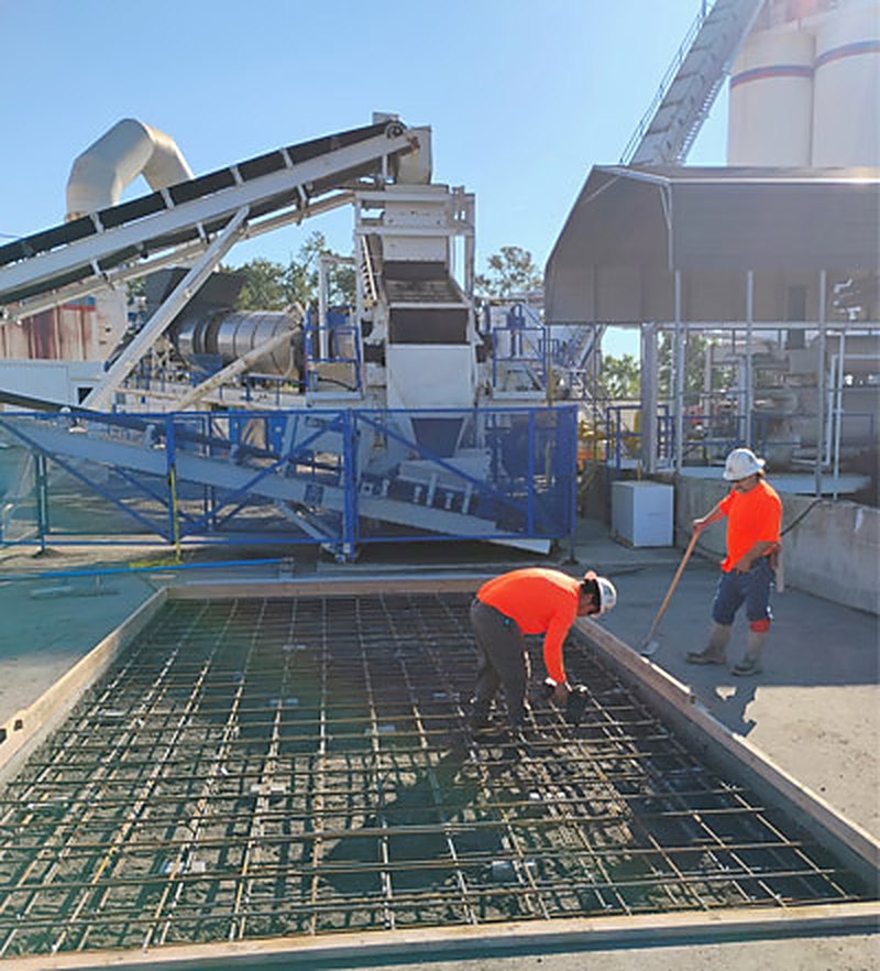 Reinforcing steel tied over a formed pit at an aggregate processing plant