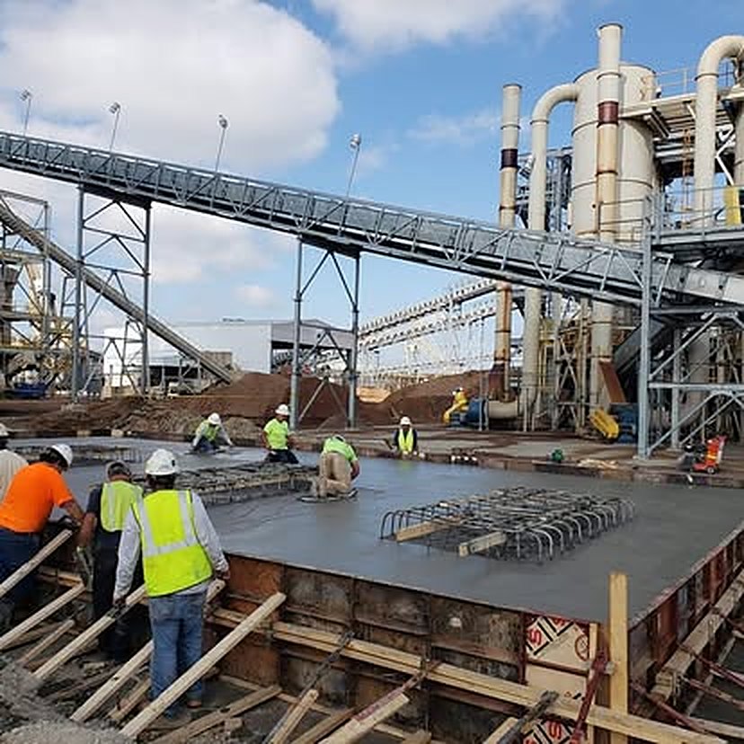 Crew finishing a heavy structural slab at an industrial processing plant