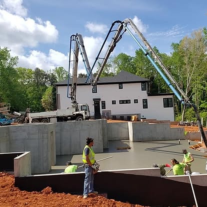 Twin boom pumps placing a residential foundation and basement slab
